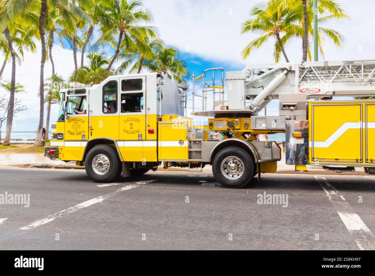 Honolulu, Hawaii, Stati Uniti - 22 febbraio 2024 - Un veicolo giallo brillante dei vigili del fuoco di Honolulu che viaggia lungo il lungomare di Waikiki, fornendo protezione antincendio Foto Stock
