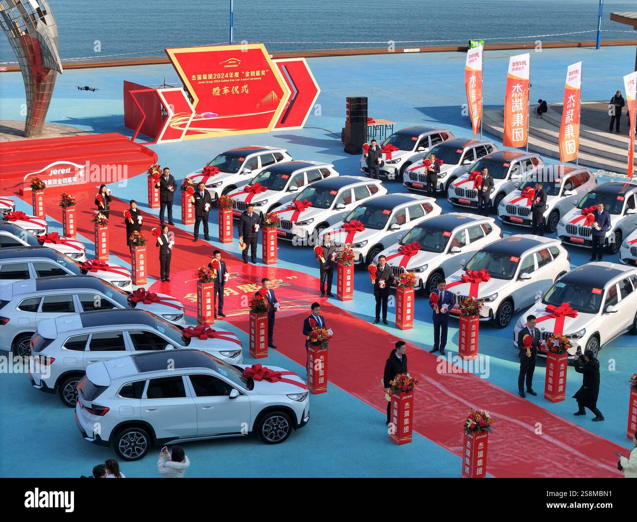 YANTAI, CINA - 23 GENNAIO 2025 - i dipendenti premiati posano per una foto con la vettura premiata durante la cerimonia di premiazione del gruppo Jierui 2024 'Go Foto Stock