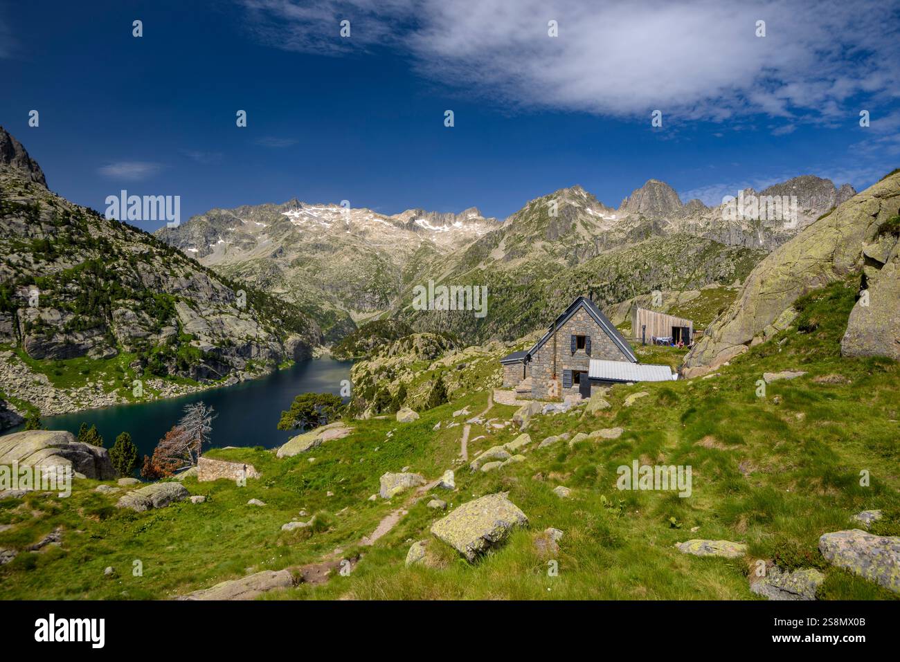Rifugio Ventosa i Calvell, con i monti Besiberris e Tumeneia sullo sfondo, nel parco nazionale Aigüestortes i Estany de Sant Maurici. Pirenei Foto Stock