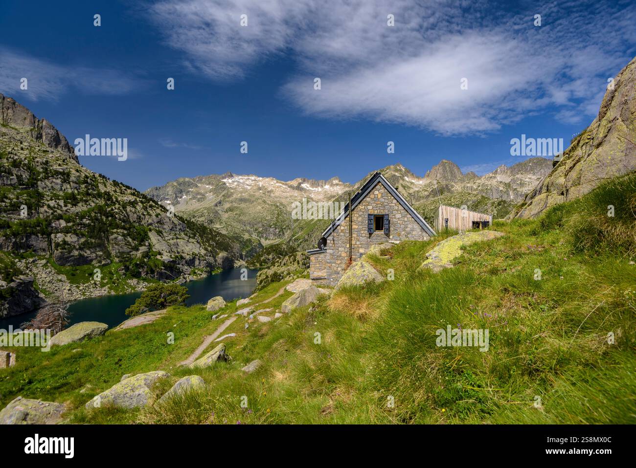 Rifugio Ventosa i Calvell, con i monti Besiberris e Tumeneia sullo sfondo, nel parco nazionale Aigüestortes i Estany de Sant Maurici. Pirenei Foto Stock