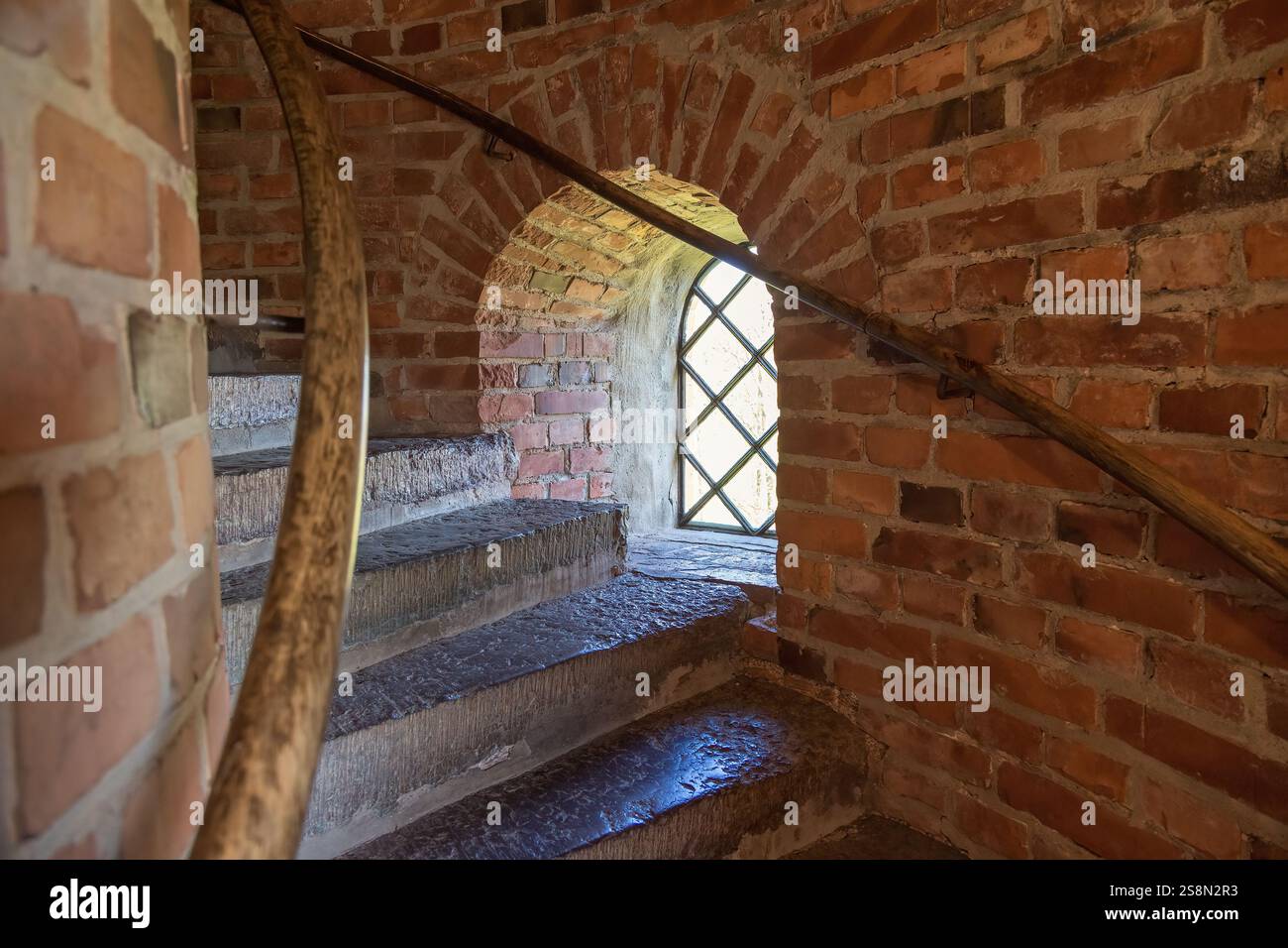 Scale con ringhiera in legno e una finestra in una torre Foto Stock