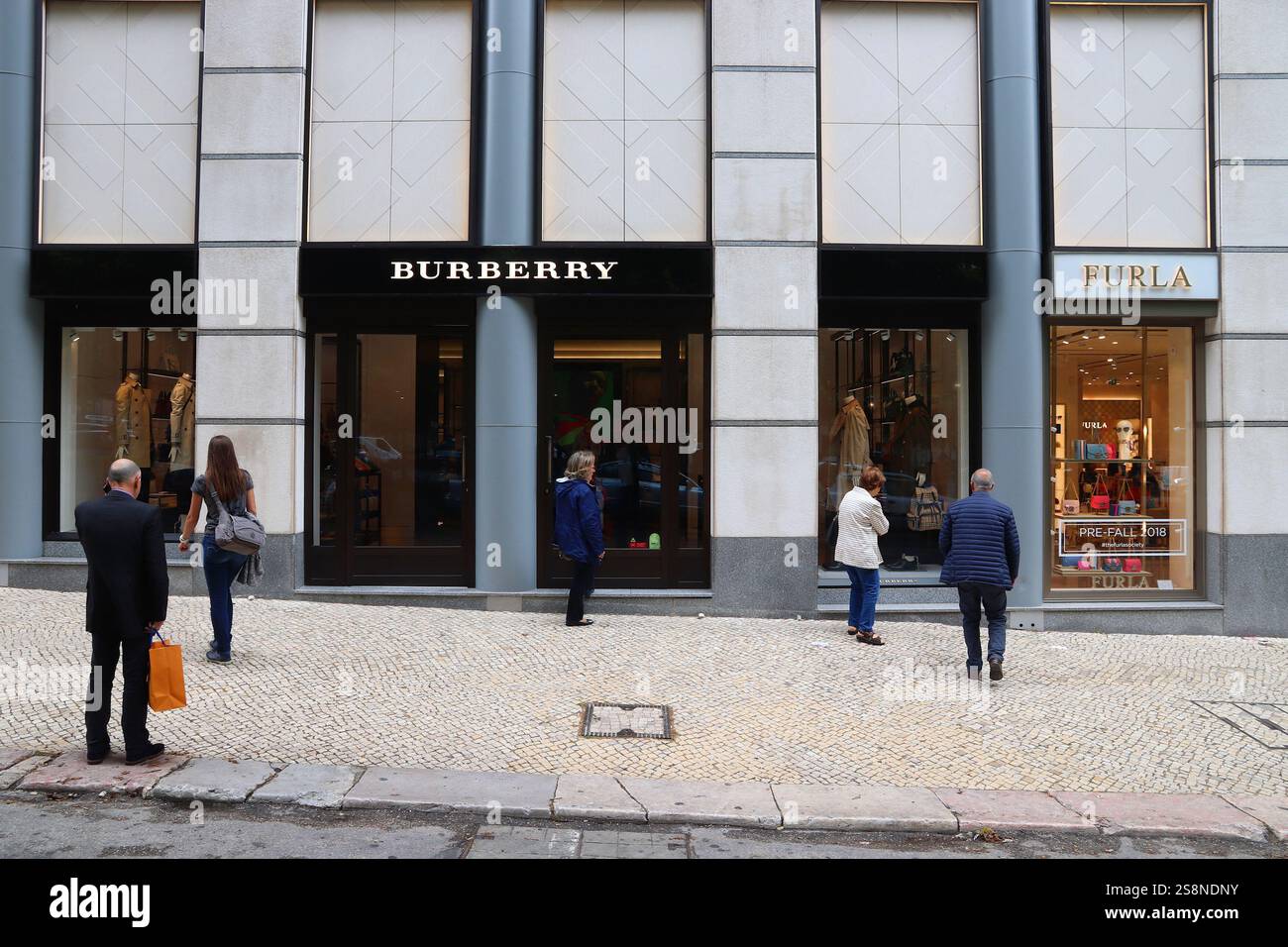 LISBONA, PORTOGALLO - 6 GIUGNO 2018: Le persone passano accanto a Burberry e Furla, negozio di moda di lusso presso Avenida da Liberdade a Lisbona. Foto Stock