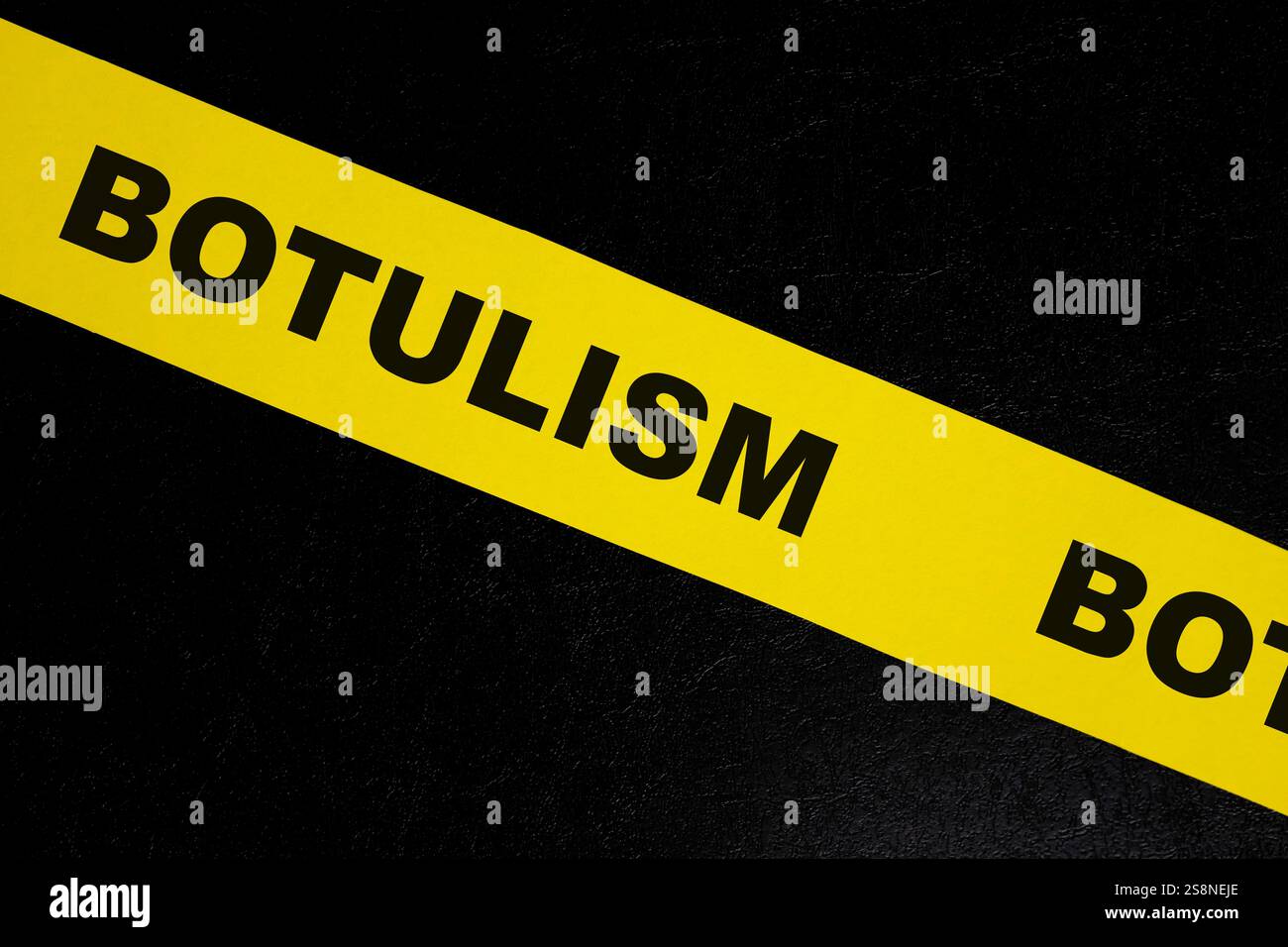 Concetto di attenzione, pericolo e avvertenza per avvelenamento da cibo botulismo. Nastro da barricata giallo con scritta su sfondo nero scuro. Foto Stock