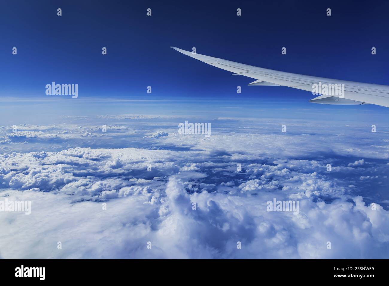 Vista dalla finestra dell'aeromobile durante un volo sull'India con la compagnia aerea Etihad. Cielo blu e strutture nuvolose sul mare, ala di un Boeing 787 Air Foto Stock