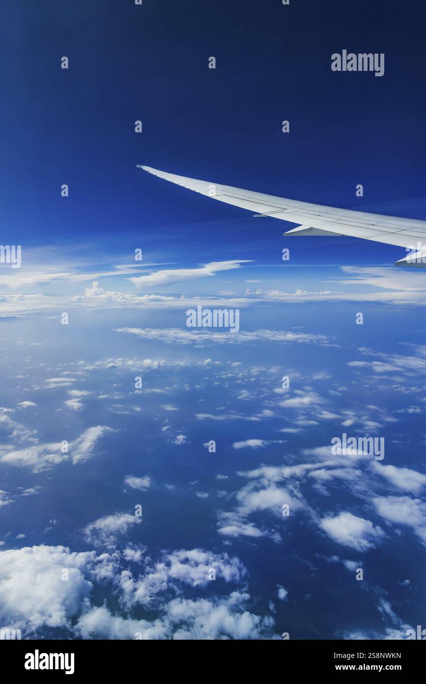 Vista dalla finestra dell'aeromobile durante un volo sull'India con la compagnia aerea Etihad. Cielo blu e strutture nuvolose sul mare, ala di un Boeing 787 Air Foto Stock