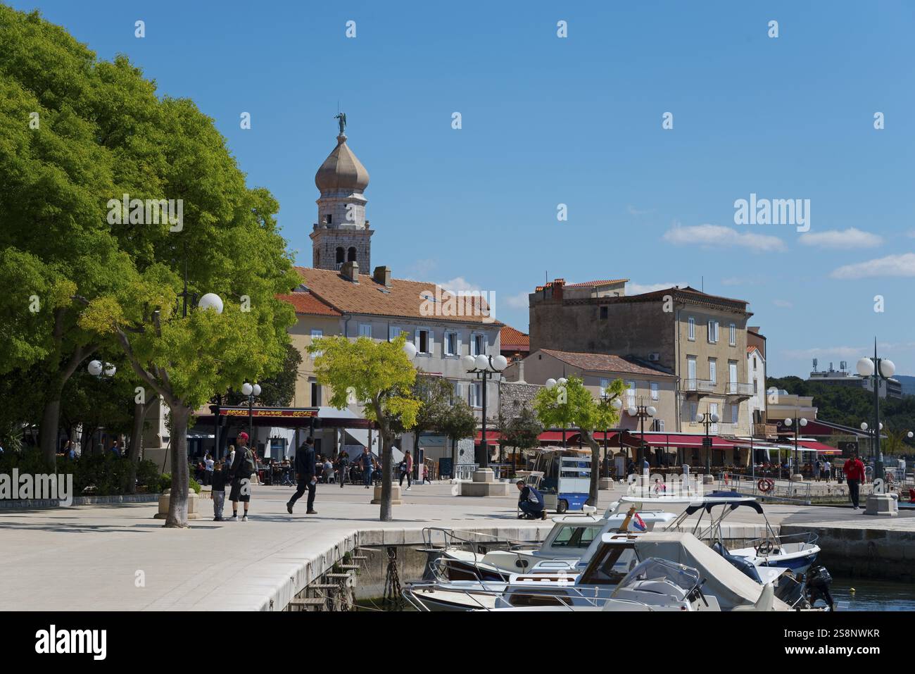 Pittoresca cittadina portuale con edifici storici, torre della chiesa e numerose barche al sole, porto, città vecchia, Krk con basilica di Santa Maria Foto Stock