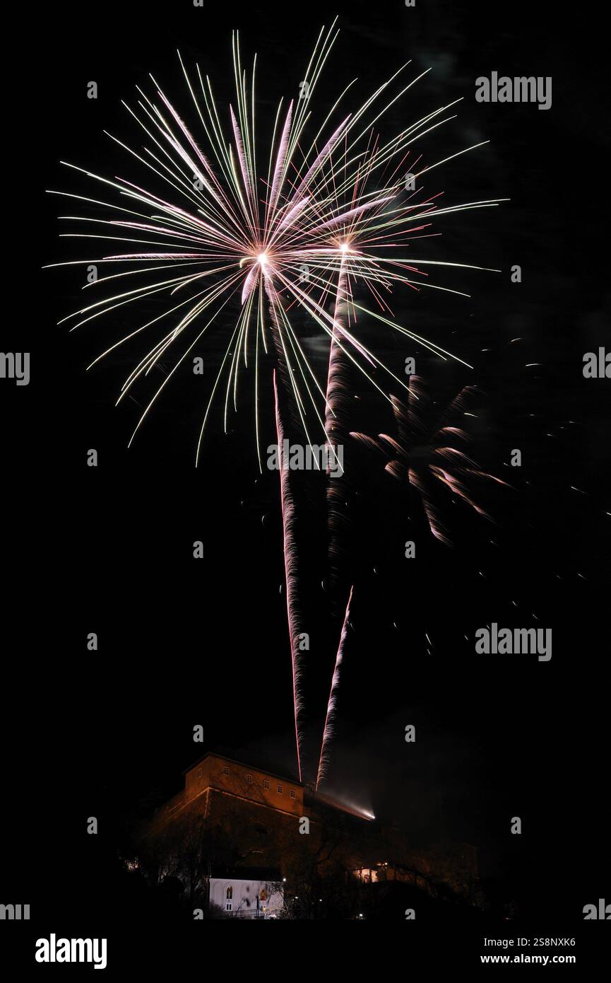 I fuochi d'artificio bianco-verdastro illuminano il cielo sopra un edificio di notte, Capodanno, Stallbastei, Schlossberg, Graz, Stiria Foto Stock