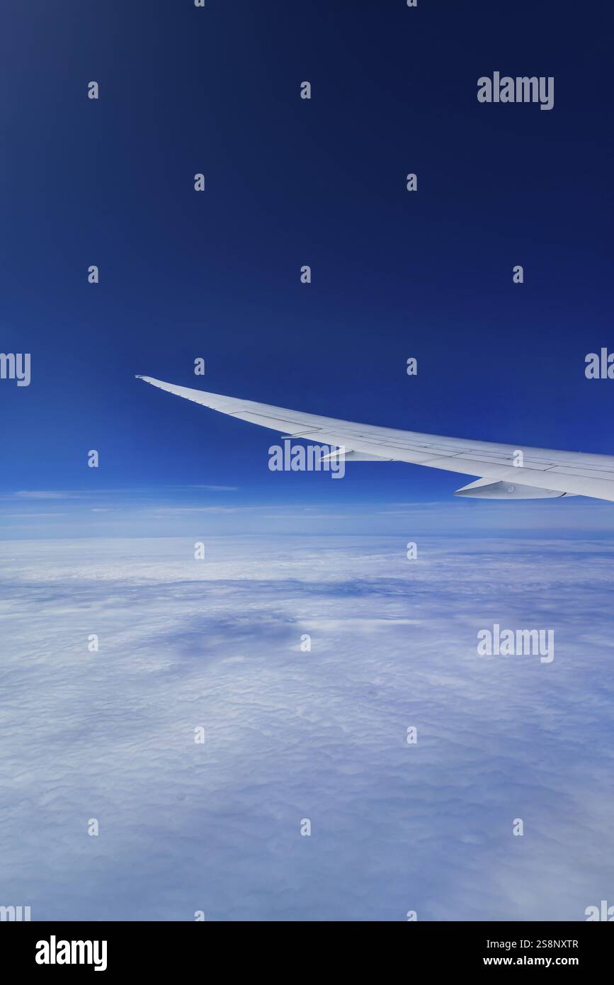 Vista dalla finestra dell'aeromobile durante un volo sull'India con la compagnia aerea Etihad. Cielo blu e strutture nuvolose sul mare, ala di un Boeing 787 Air Foto Stock