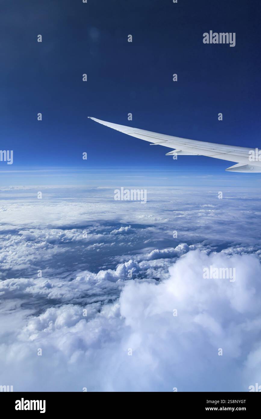 Vista dalla finestra dell'aeromobile durante un volo sull'India con la compagnia aerea Etihad. Cielo blu e strutture nuvolose sul mare, ala di un Boeing 787 Air Foto Stock