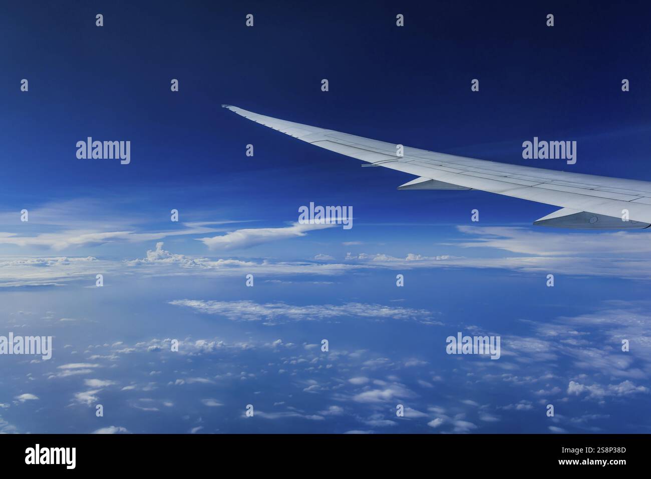 Vista dalla finestra dell'aeromobile durante un volo sull'India con la compagnia aerea Etihad. Cielo blu e strutture nuvolose sul mare, ala di un Boeing 787 Air Foto Stock