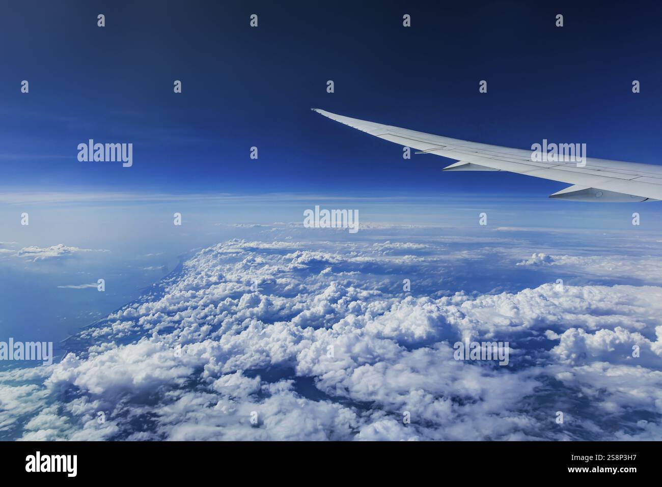 Sopra le nuvole sull'Oceano Indiano. A sinistra, la costa dell'India. Vista dalla finestra dell'aeromobile durante un volo con la compagnia aerea Etihad. S. Blu Foto Stock