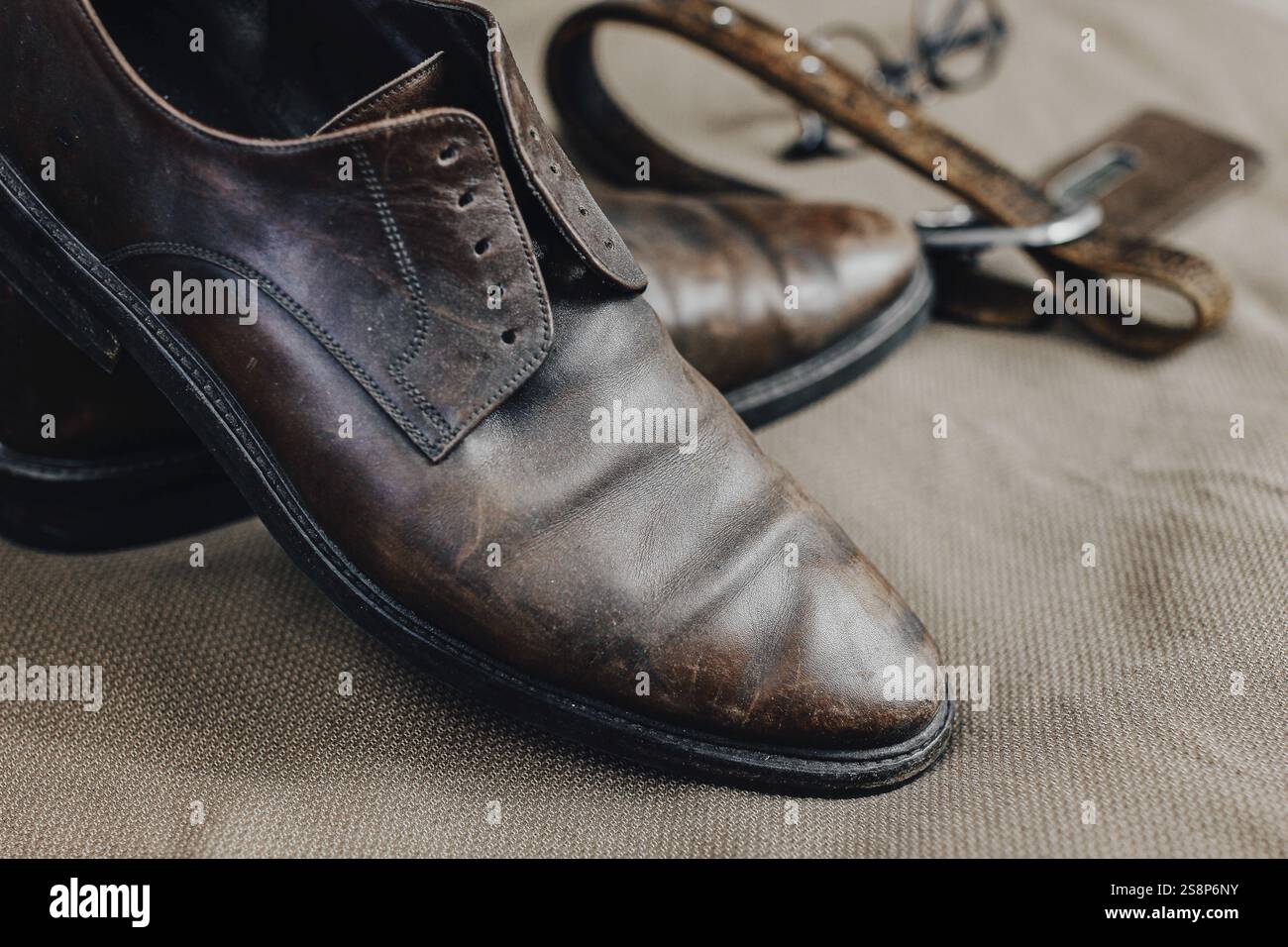 Un paio di scarpe in pelle marrone indossate su una superficie ruvida Foto Stock