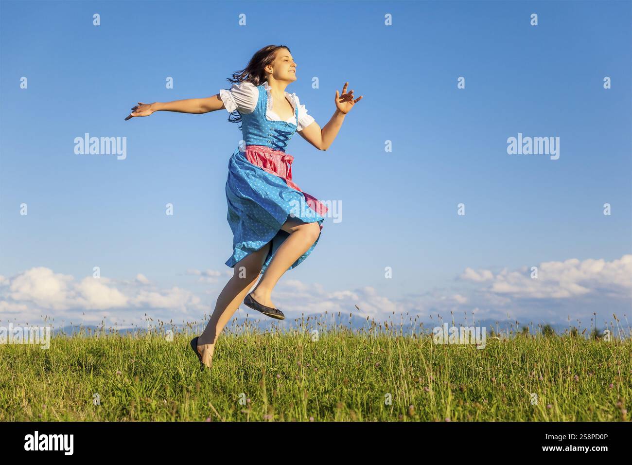 Una donna nel tradizionale bavarese dirndl nella natura Foto Stock