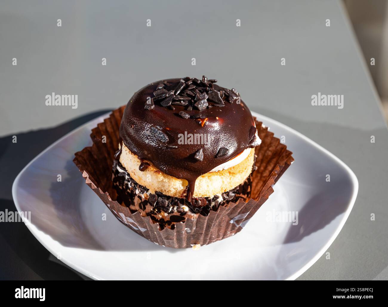 Torta di meringa ricoperta di cioccolato. Fotografia gastronomica su un tavolo grigio Foto Stock