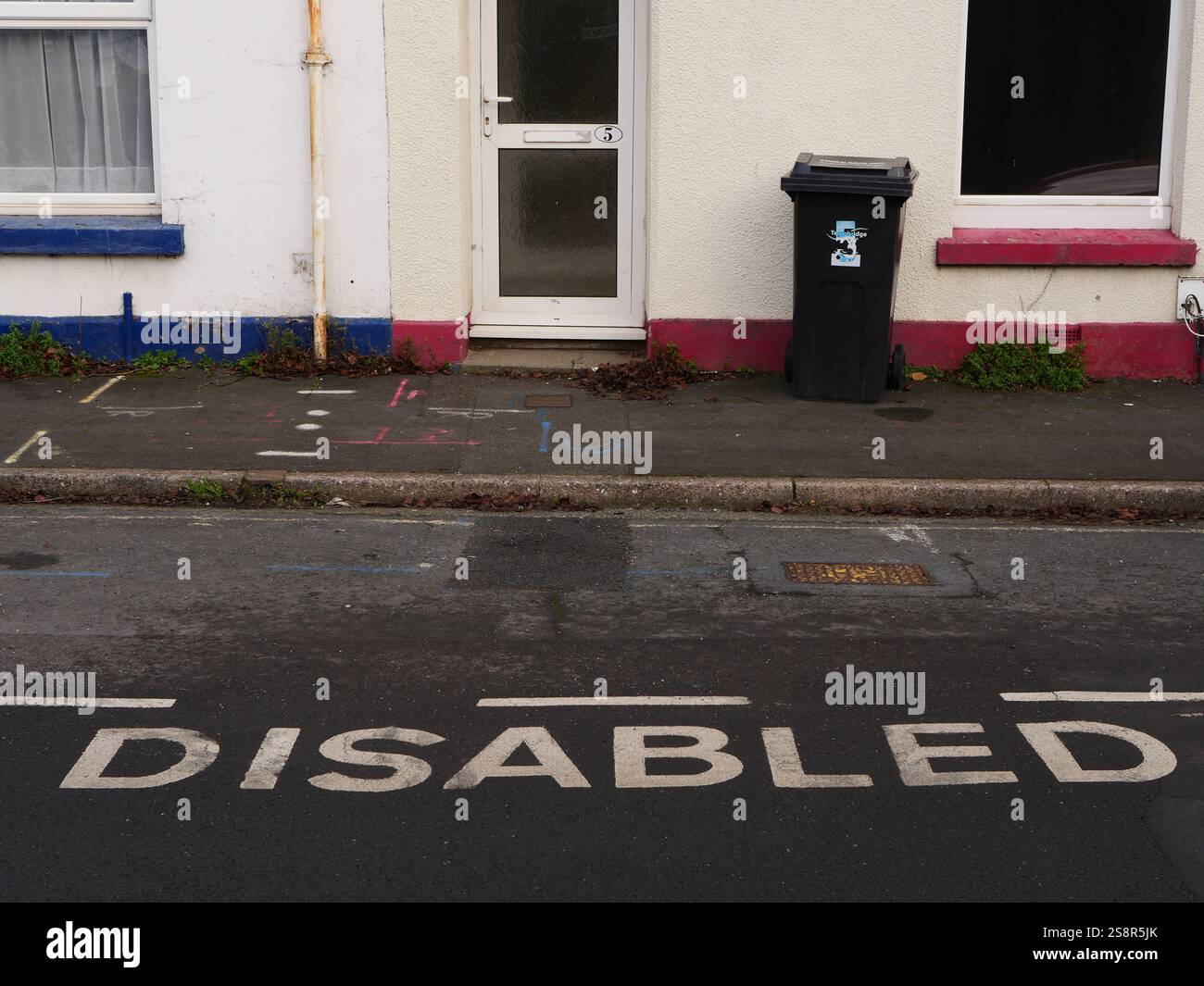 Parcheggio per disabili segnalato su una strada residenziale fuori da un albergo a schiera. Foto Stock