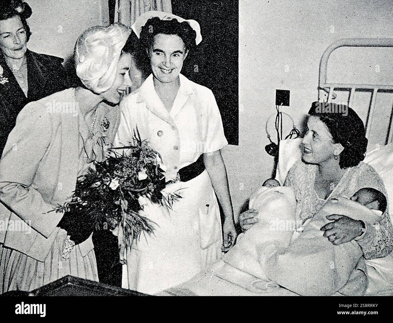 Ammirando i gemelli della signora Harvey, moglie del C.P.O. Harvey, di H.M.S. Chequers. La principessa Elisabetta e la contessa Mounbatten Foto Stock