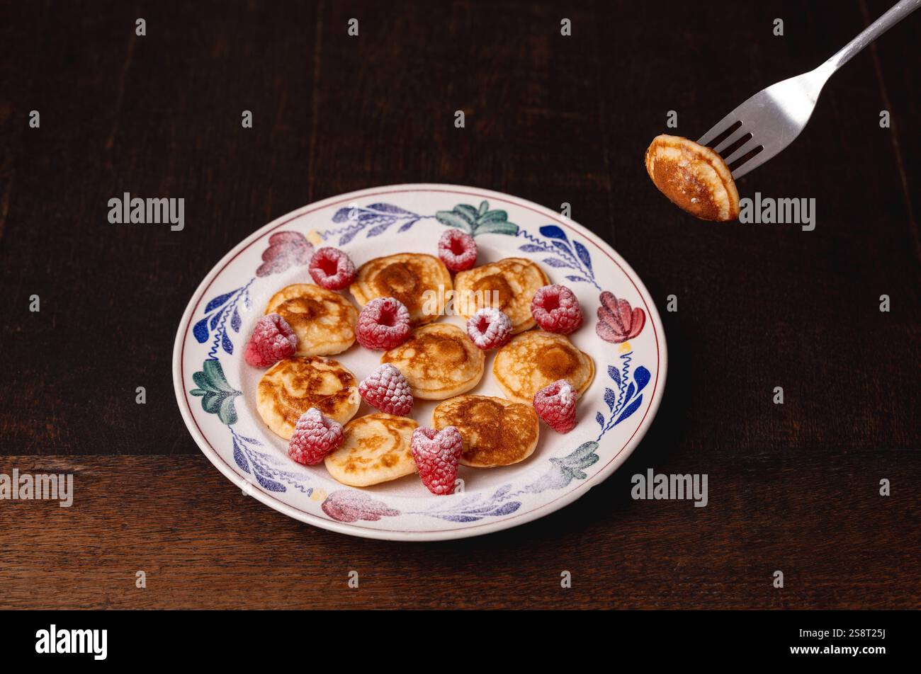 Mangiando tradizionali poffertjes olandesi, tipico dolce olandese che assomiglia a piccoli pancake Foto Stock