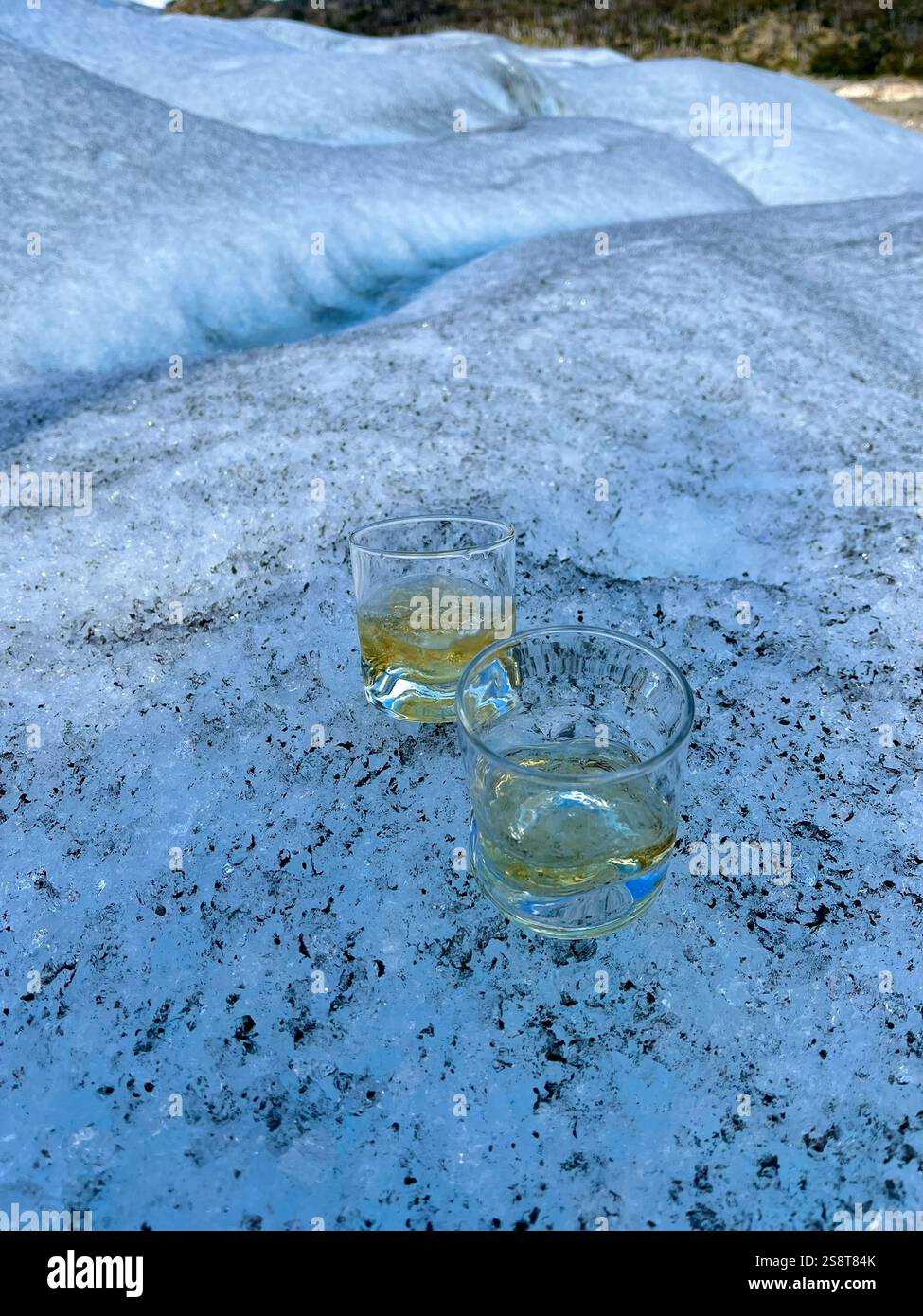 Bicchiere di whisky con ghiaccio prelevato dal ghiacciaio Perito Moreno Foto Stock