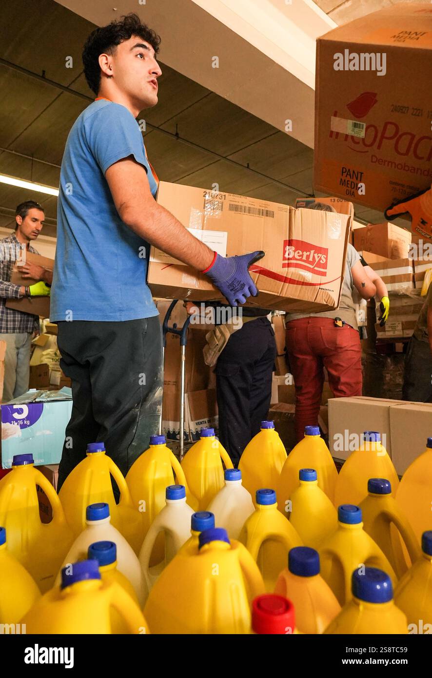 Lavoratori che passano scatole di cartone nel magazzino di emergenza di IKEA Alfafar per fornire aiuto umanitario e sostegno alle aree colpite da DANA. Foto Stock