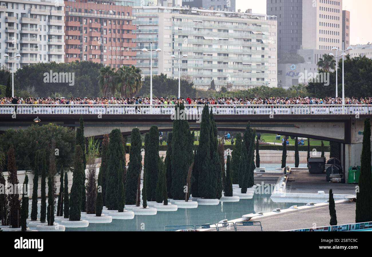 Corridori che corrono sul ponte di Monteolivete con grandi edifici sullo sfondo durante l'edizione 2024 di Maratón Valencia Trinidad Alfonso. Foto Stock