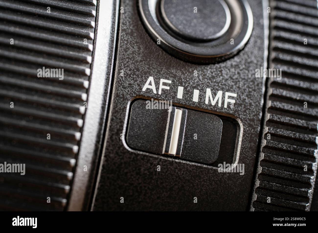 Primo piano del pulsante di messa a fuoco automatica o manuale sul nuovo obiettivo della fotocamera. AF e mf attivano l'obiettivo della fotocamera, i comandi di una fotocamera mirrorless, macro Foto Stock