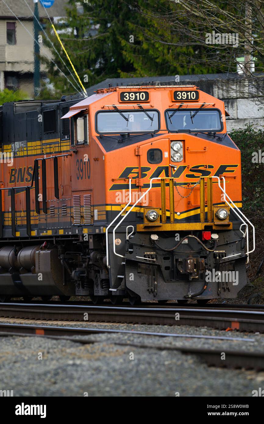 Everett, WA, USA - 20 gennaio 2025; locomotiva diesel arancione BNSF in primo piano con logo Swoosh Foto Stock