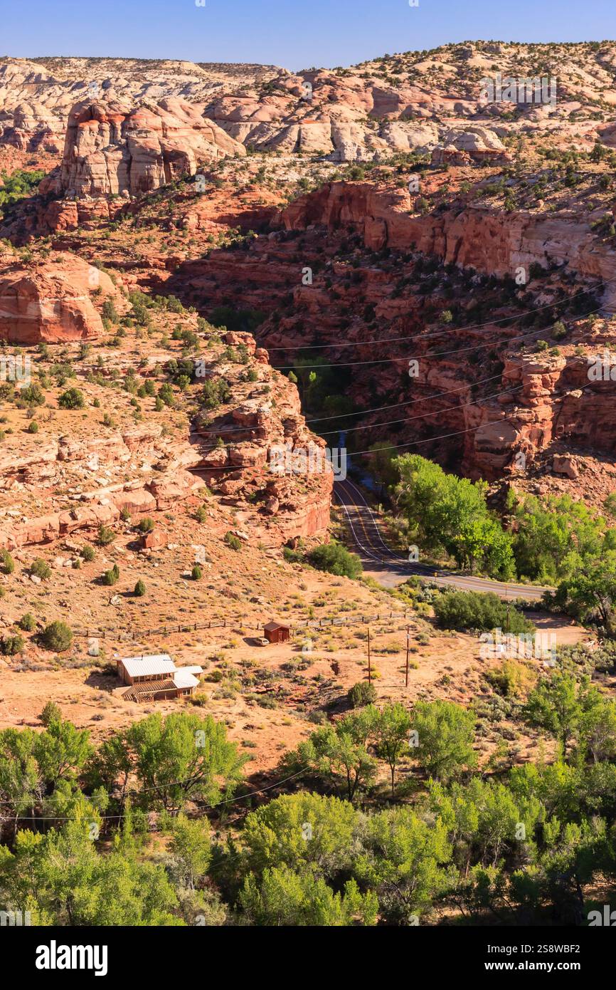 Una catena montuosa con una strada sterrata che la attraversa. La strada è circondata da alberi e le montagne sono ricoperte di rocce rosse Foto Stock