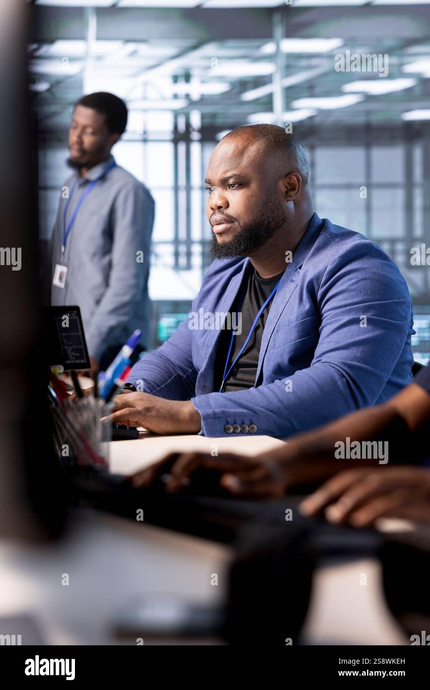 Tecnico di sicurezza informatica che monitora gli incidenti di sicurezza che interessano lo spazio di lavoro dell'hub server. Amministratore di sistema nel data center che protegge l'infrastruttura critica dell'azienda dalle minacce informatiche Foto Stock