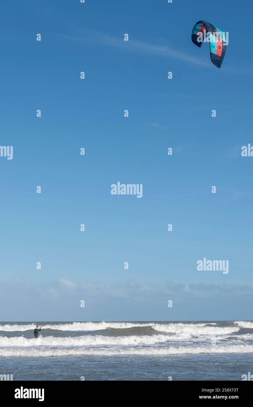 10 marzo 2021 - Valeria del Mar, Buenos Aires, Argentina: Kite surfer cavalca abilmente le onde sotto un cielo soleggiato Foto Stock