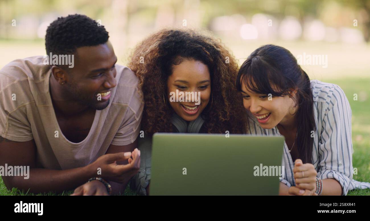 Studenti, laptop e amici felici studiano al parco all'aperto per imparare, ridere o leggere meme divertenti. Gruppo, computer e istruzione all'università Foto Stock