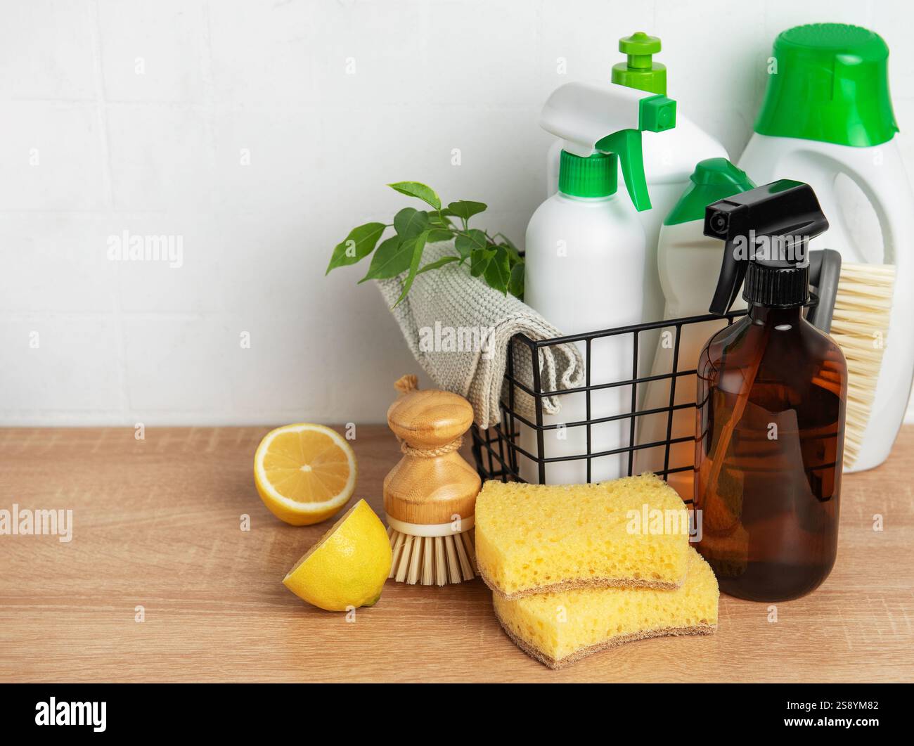 Prodotti per la pulizia eco-compatibili disposti su una superficie in legno, che enfatizzano la sostenibilità della pulizia Foto Stock