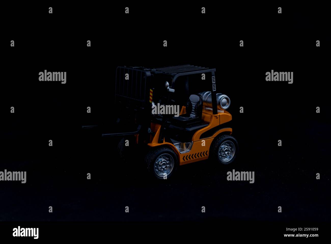 Carrello elevatore giocattolo giallo su sfondo nero Foto Stock