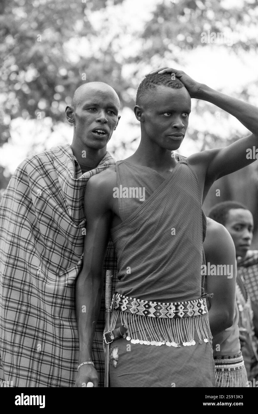 Gruppo di uomini Maasai in danza tradizionale all'aperto in bianco e nero Foto Stock