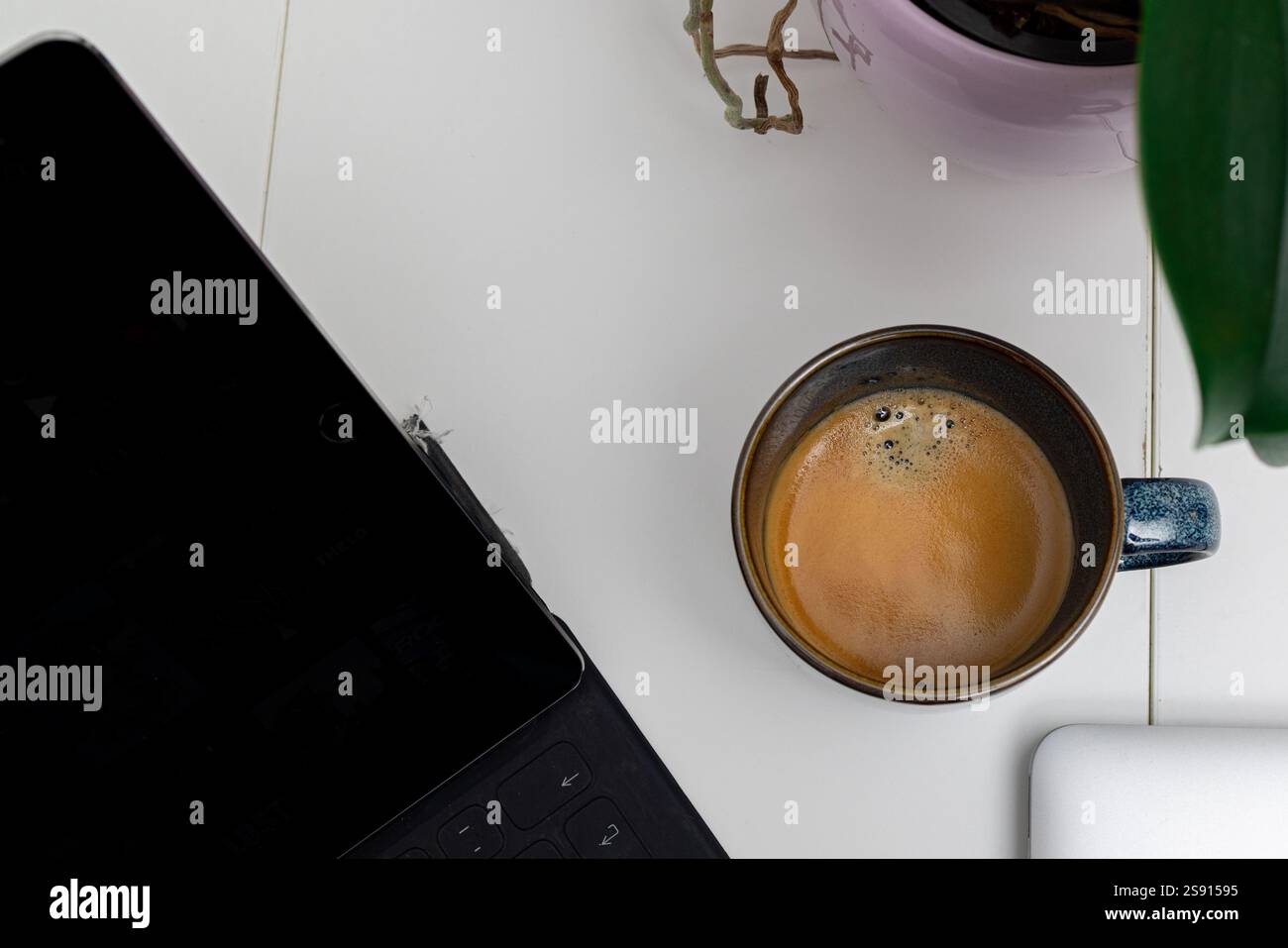 Pausa caffè con tablet e configurazione minimalista dell'area di lavoro Foto Stock
