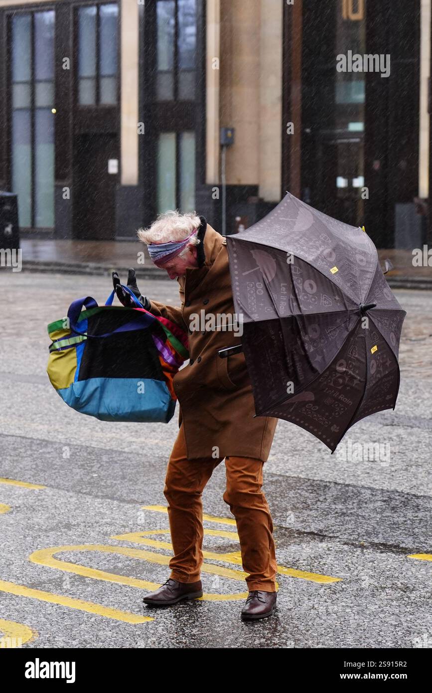 Un membro delle battaglie pubbliche con un ombrello al vento durante la tempesta Eowyn in George Street, Edimburgo. Le scuole sono state chiuse e la gente ha avvertito di non viaggiare venerdì, poiché i venti a 100 km/h rappresentano un pericolo per la vita in alcune parti del Regno Unito mentre la tempesta Eowyn colpisce il paese. Data foto: Venerdì 24 gennaio 2025. Foto Stock
