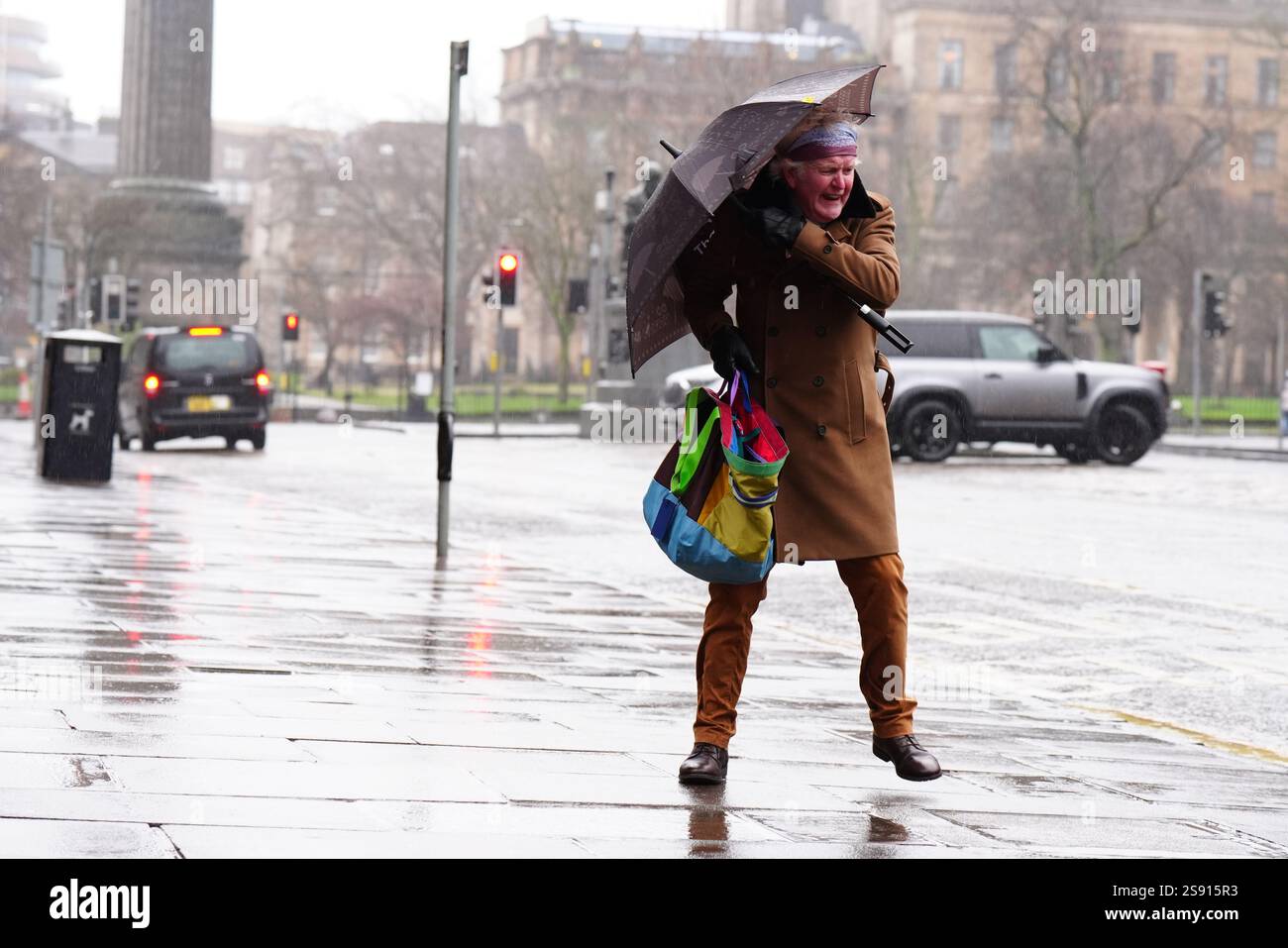 Un membro delle battaglie pubbliche con un ombrello al vento durante la tempesta Eowyn in George Street, Edimburgo. Le scuole sono state chiuse e la gente ha avvertito di non viaggiare venerdì, poiché i venti a 100 km/h rappresentano un pericolo per la vita in alcune parti del Regno Unito mentre la tempesta Eowyn colpisce il paese. Data foto: Venerdì 24 gennaio 2025. Foto Stock