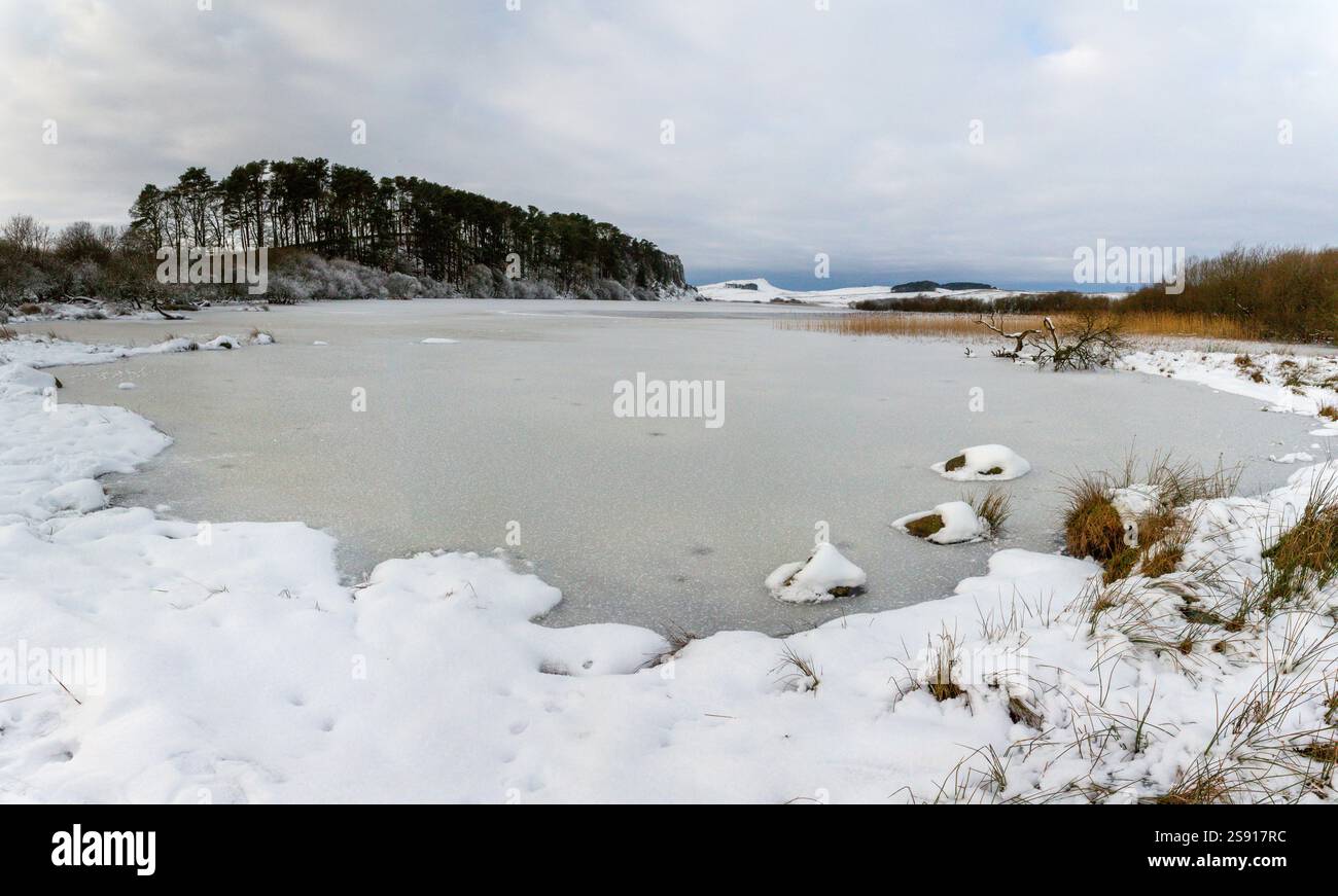 Un paesaggio innevato al Vallo di Adriano, monumento storico e percorso a piedi a lunga distanza nel Northumberland, Inghilterra nord-orientale, da Crag Lough Foto Stock