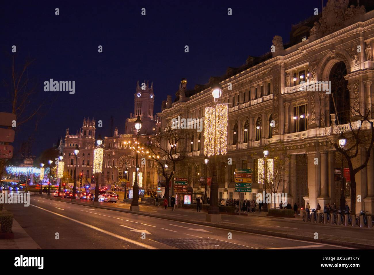 Madrid, Spagna - 24 gennaio 2025: Vista notturna dell'edificio della Banca di Spagna a Madrid con semafori e traffico. L'architettura storica crea Foto Stock
