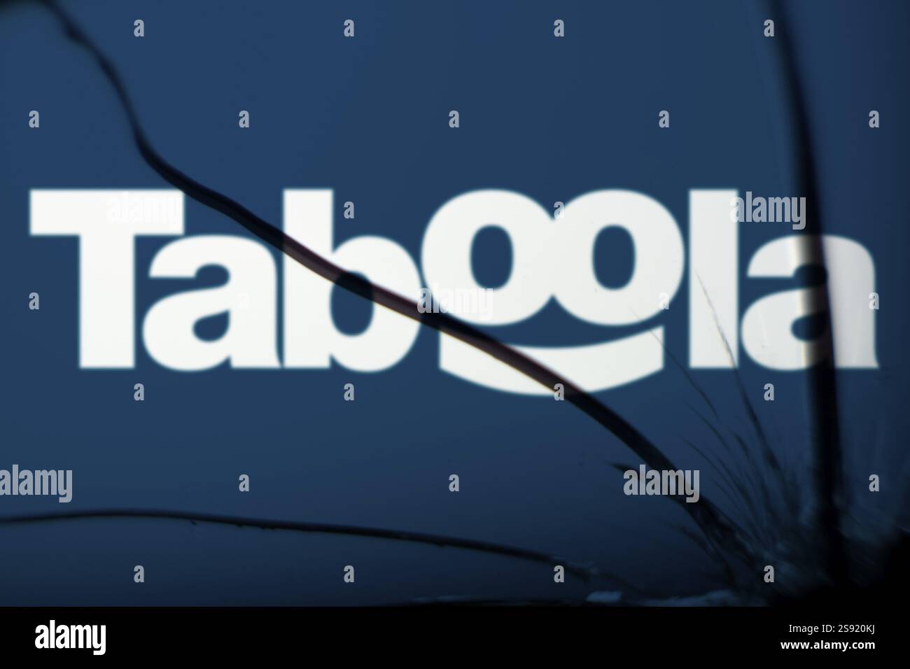 Dacca, Bangladesh - 19 gennaio 2025: Il logo della taboola è visibile sul vetro rotto. Taboola Inc è una società di pubblicità e tecnologia quotata in borsa Foto Stock