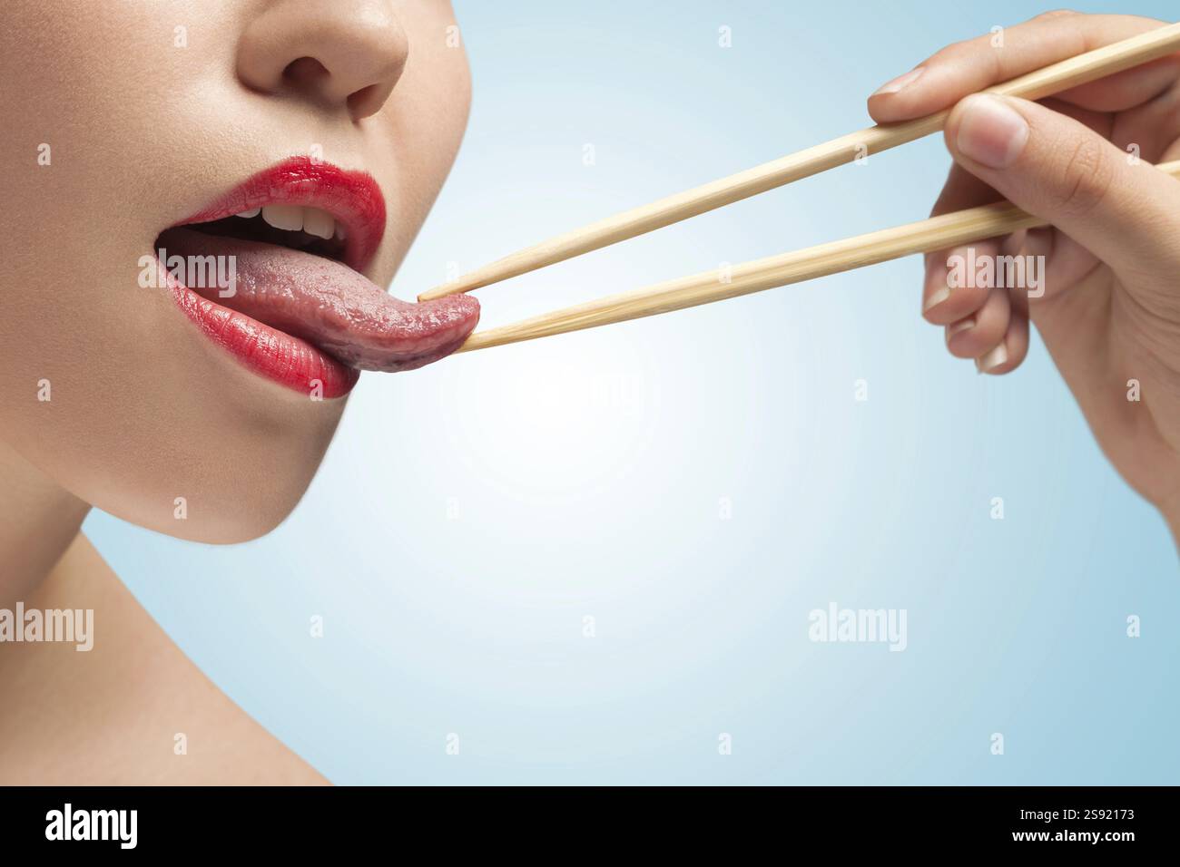 La foto della faccia inferiore della ragazza con i bastoncini di cibo Hoding Tongue Foto Stock