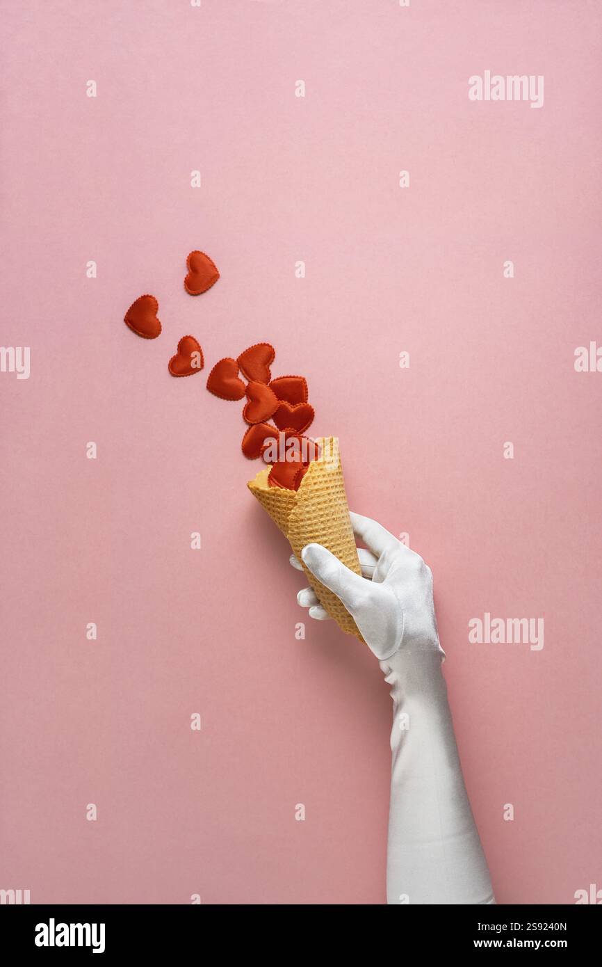 Foto creativa del concetto di cono gelato con cuori su sfondo rosa Foto Stock