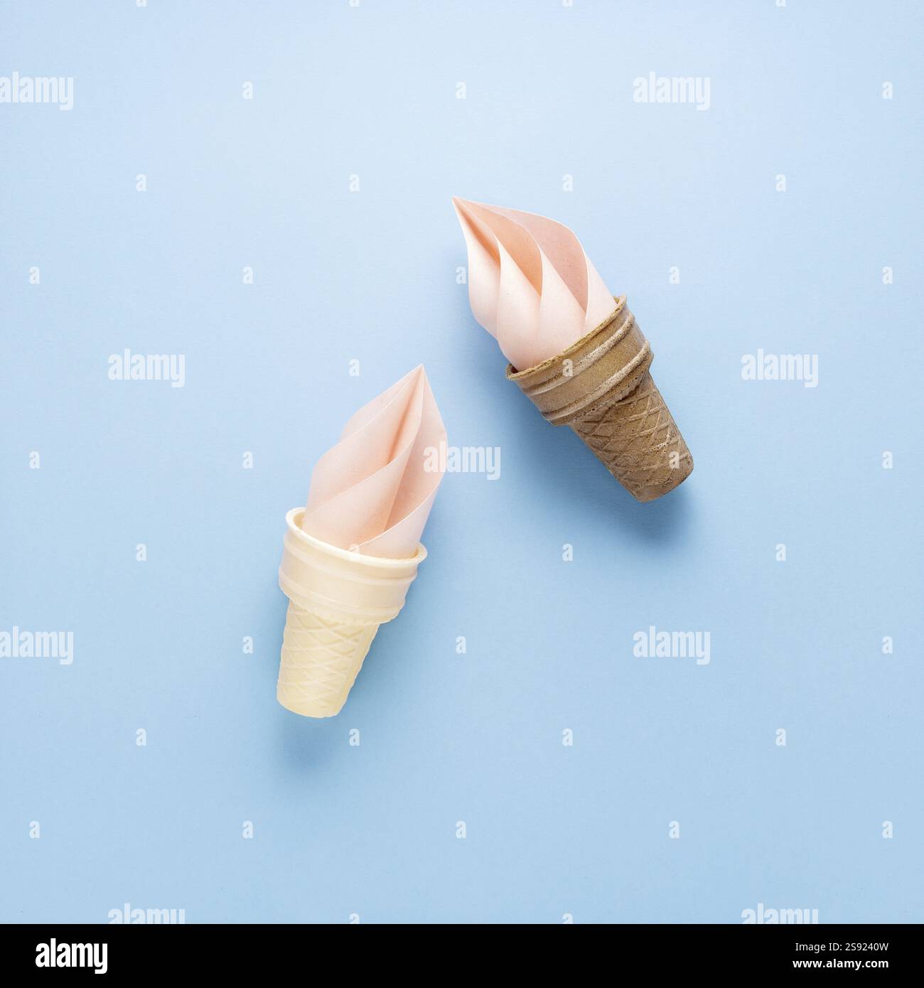 Foto creativa del cono gelato e spruzzi di carta su sfondo blu Foto Stock