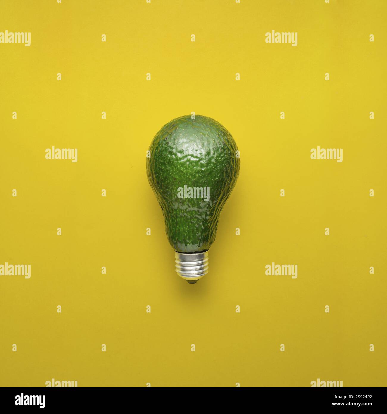 Foto creativa dell'avocado come lampadina su sfondo giallo Foto Stock