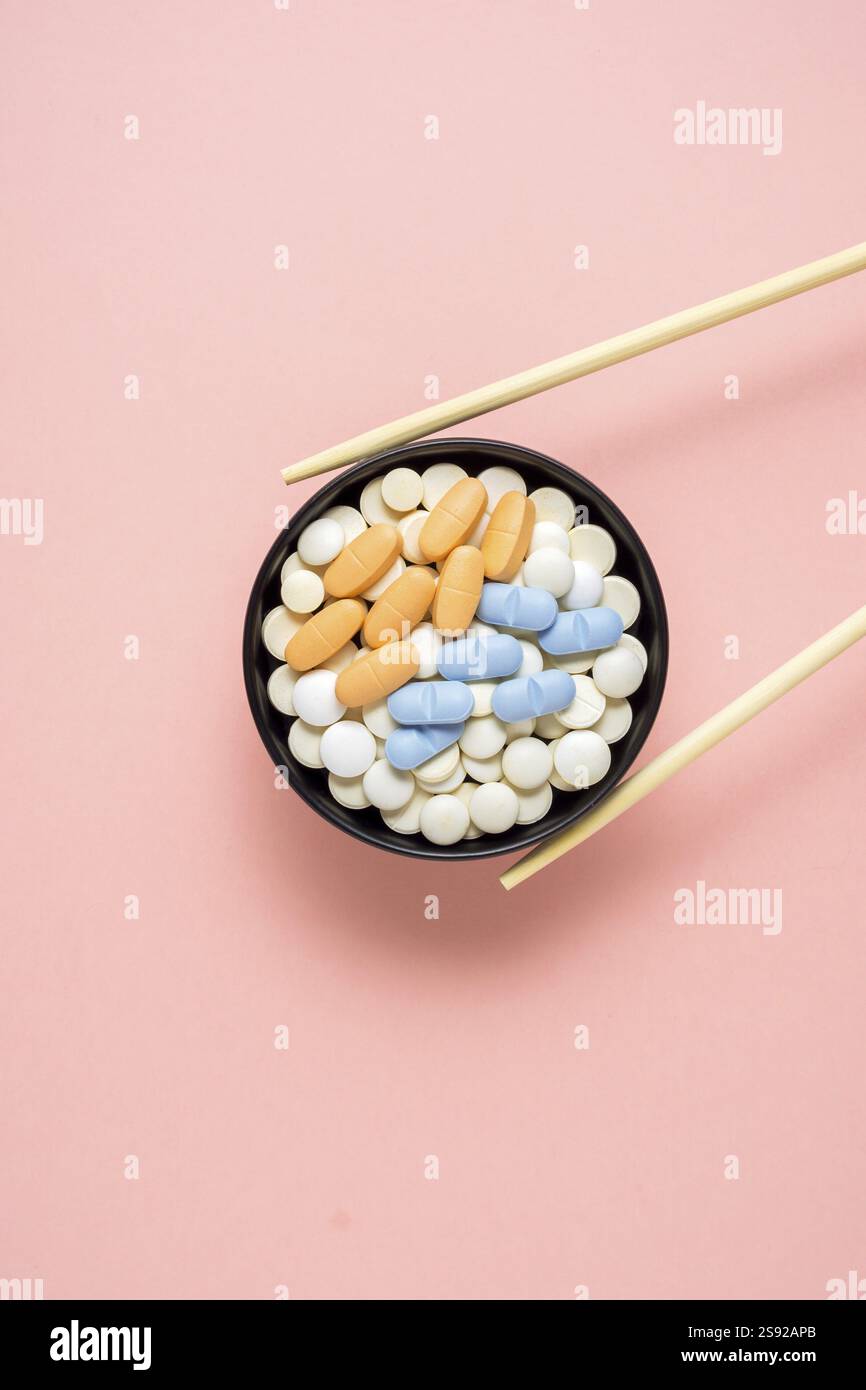 Foto creativa delle pillole disposte come sushi su sfondo rosa Foto Stock