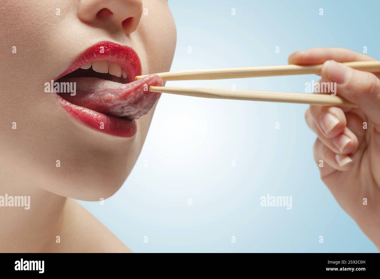 La foto della faccia inferiore della ragazza con i bastoncini di cibo Hoding Tongue Foto Stock