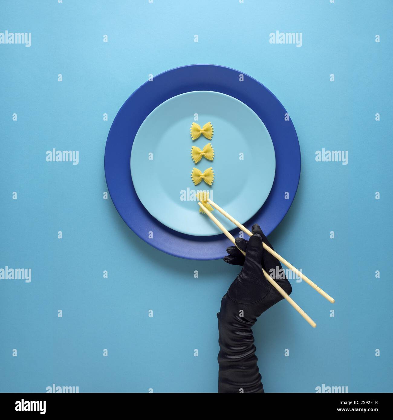 Foto creativa di oggetti da cucina con piatto dipinto a mano e cibo su sfondo blu Foto Stock