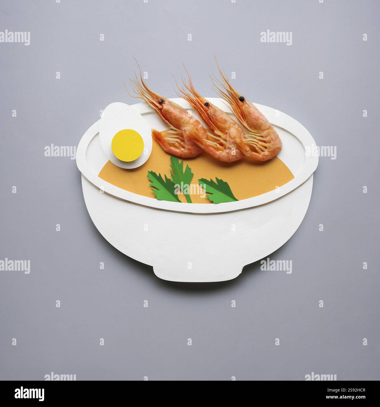 Foto creativa di zuppa con granchi di carta su sfondo grigio Foto Stock