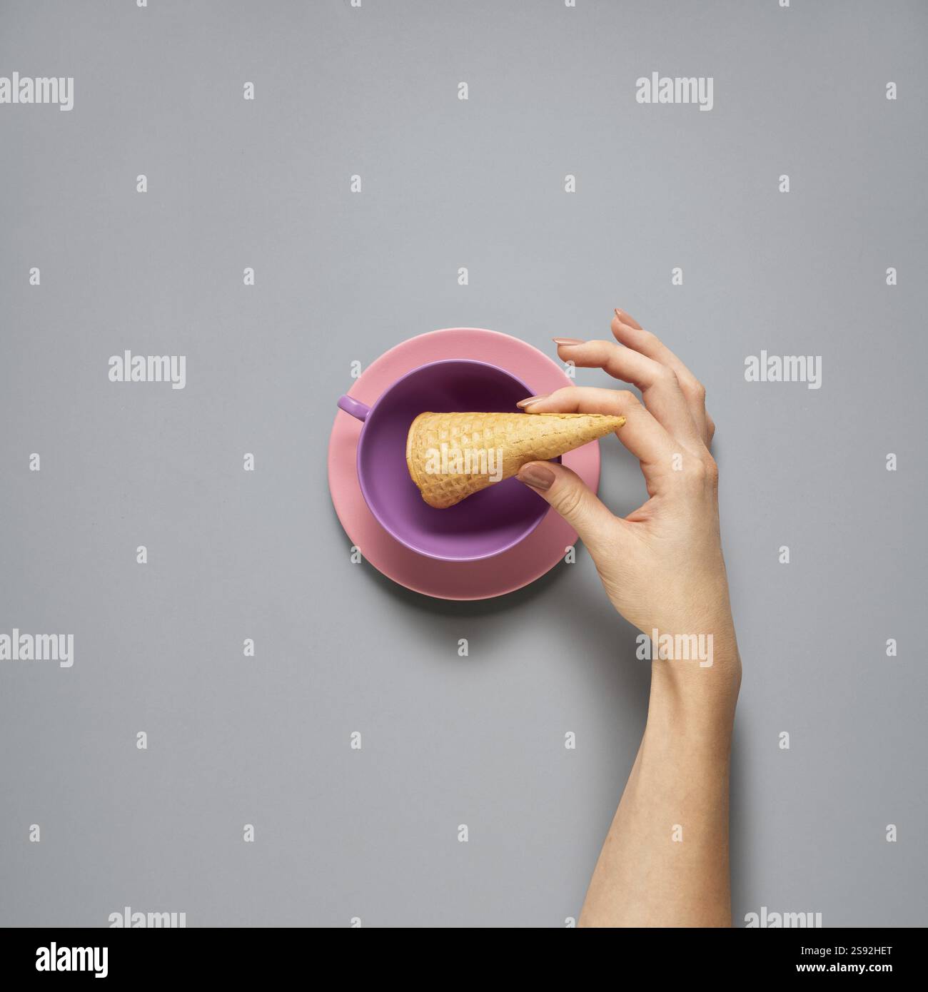 Fotografia creativa di oggetti da cucina con piatto dipinto a mano e cibo su sfondo grigio Foto Stock