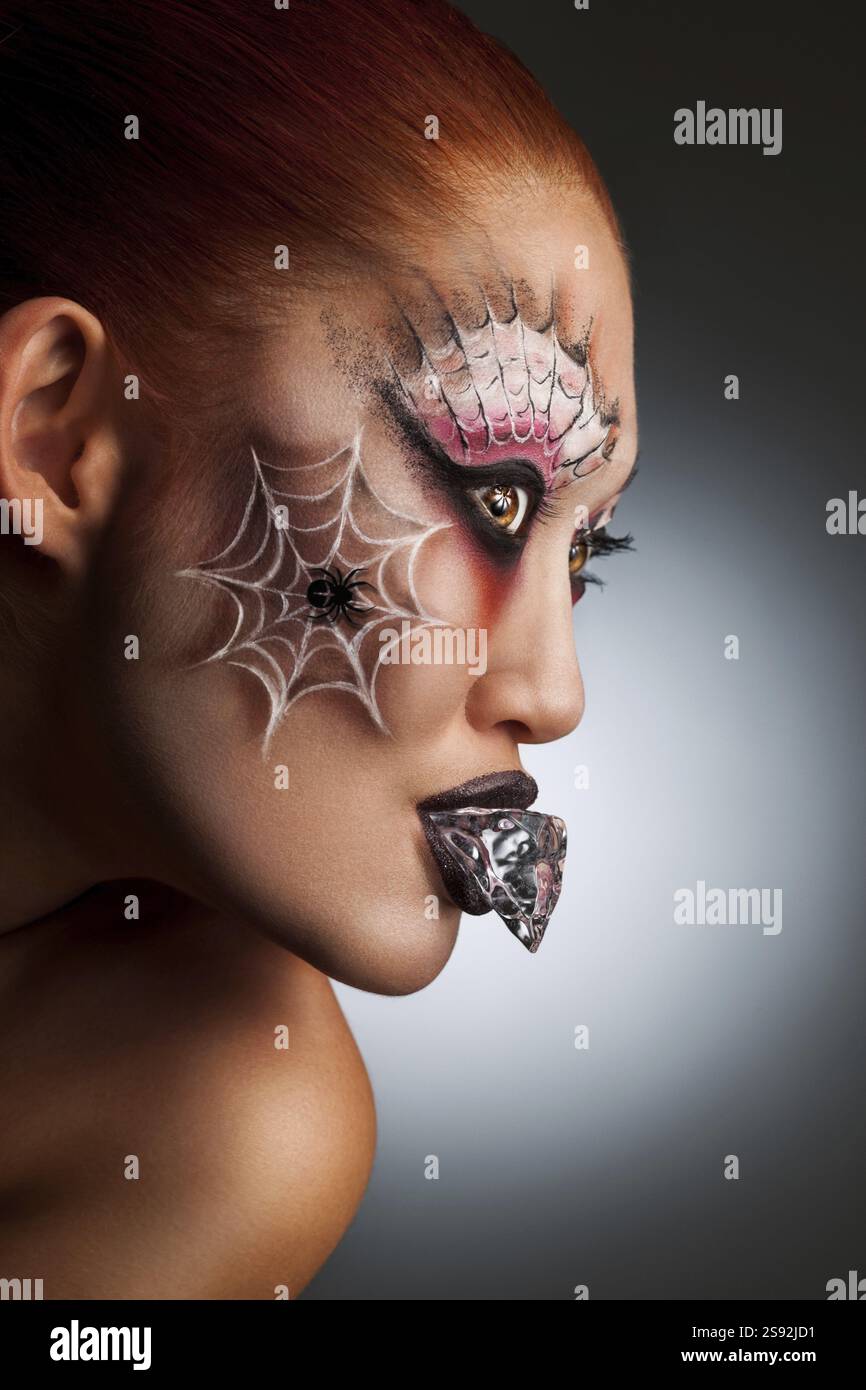 Ritratto di Halloween di una ragazza con un tatuaggio ragno sul viso Foto Stock