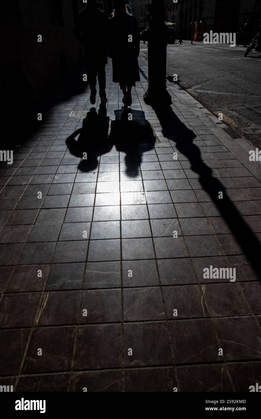Ombre di due persone che camminano per terra. Foto Stock